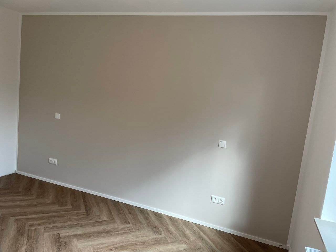 Fertige Wandfläche in warmem Greige mit gerader senkrechter Kante zur weißen Nachbarwand